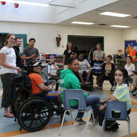 Group of young people participating in an activity at a community centre event for kids and youth with disabilities.